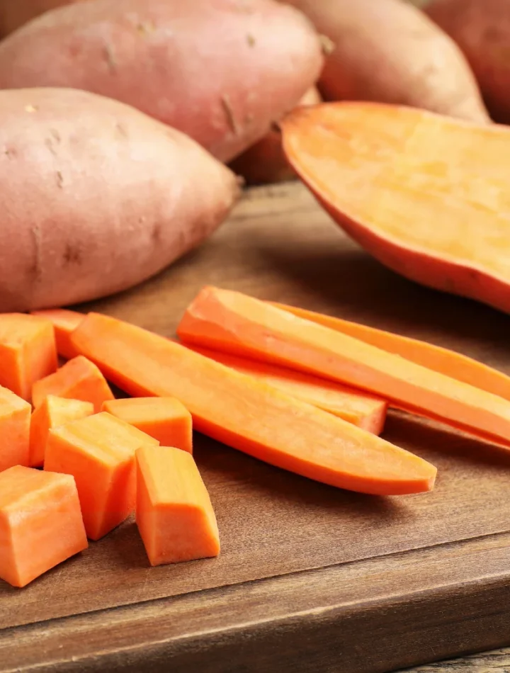 Batatas doces variadas e inhame sobre uma mesa rústica